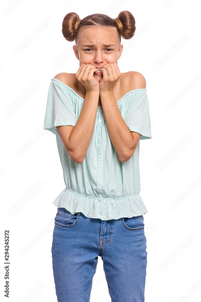 Portrait of surprised or shocked teen girl, isolated on white background. Funny child looking at camera with hand on mouth, biting nails. Beautiful teenager with opening wide eyes looking stressed.
