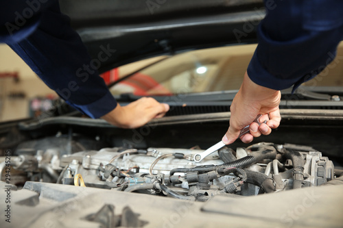 Male mechanic repairing car in service center