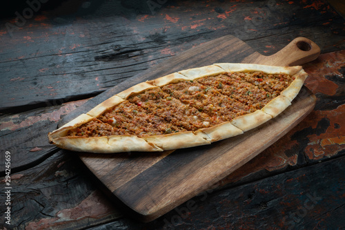 Turkish pide with vegetables isolated on rustic wooden table photo