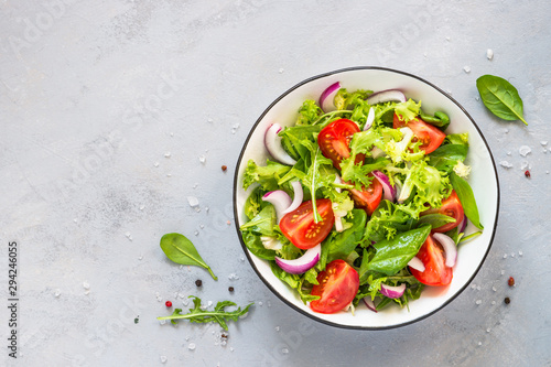 Tableau sur toile Green salad from fresh leaves and tomatoes.