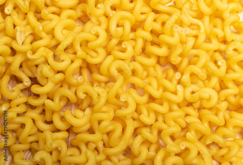 Raw yellow cavatappi pasta texture background top view