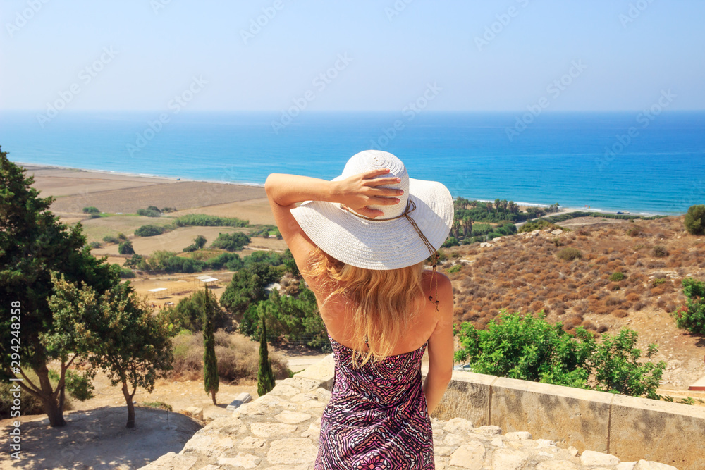 Portrait of beautiful woman wearing wide straw hat looking to the sea side