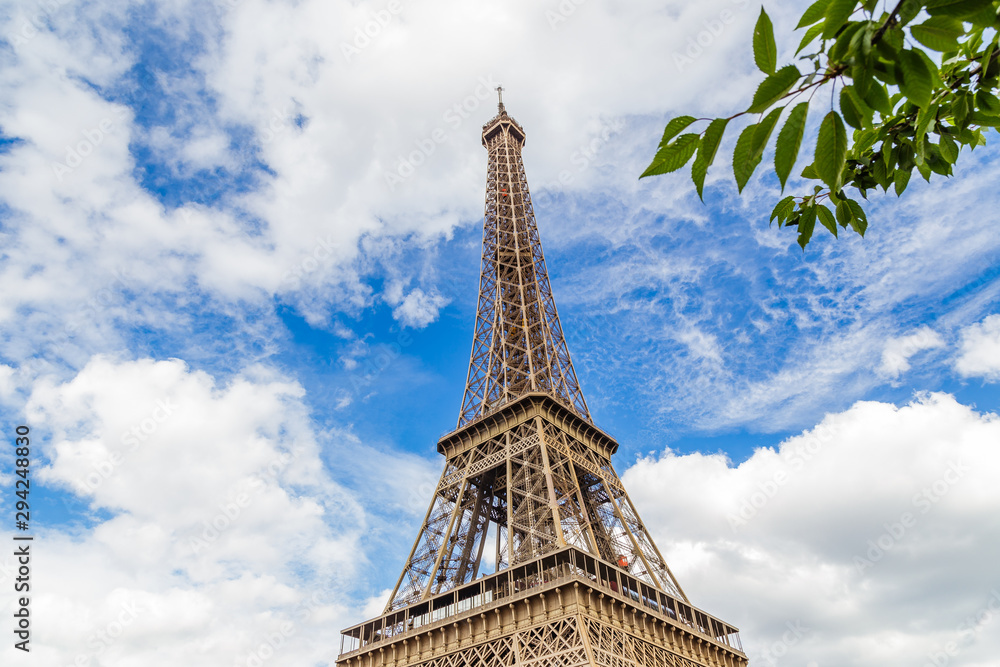 Eiffel Tower in Paris France on a beautiful Spring day with blue sky and white clouds