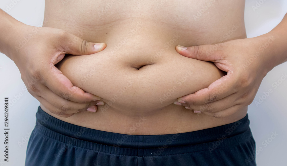 Naklejka premium Overweight Asian obese men, He is feeling ill and worried about his excess weight. He squeezed his belly, showing the excess fat that was isolated on a white background