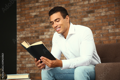 Smiling young man reading b...