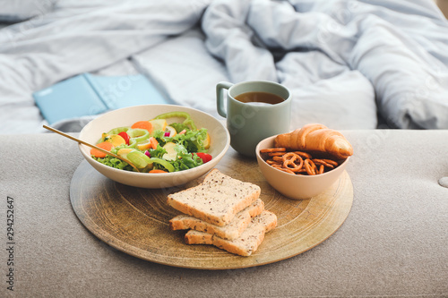 Tray with tasty breakfast in bedroom