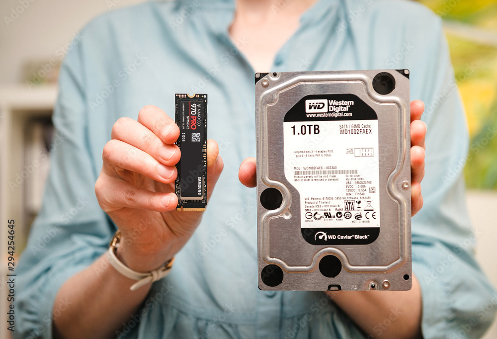 Foto Stock PARIS, FRANCE - AUG 3, 2018: Woman hands holding new Samsung 870  Pro NVME PCIE SSD hard drive disk next to HDD disk drive Western Digital  comparing two technologies, upgrade | Adobe Stock