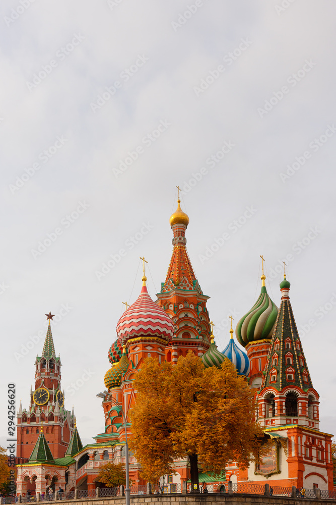 Saint Basil’s Cathedral on Red Square of Moscow, Russia, Spassky (Savior’s) tower of the Kremlin in autumn. Vertical photo. Travel or tourism theme or decoration