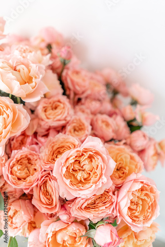 Roses of multicolor  pastel pink and pale orange color. Lots of buds. Floral natural backdrop. Flower shop concept