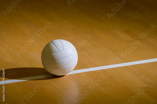 Volleyball court wooden floor with ball on black with copy-space
