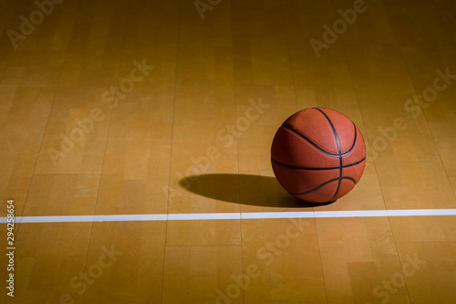 A basketball on the wooden floor as background