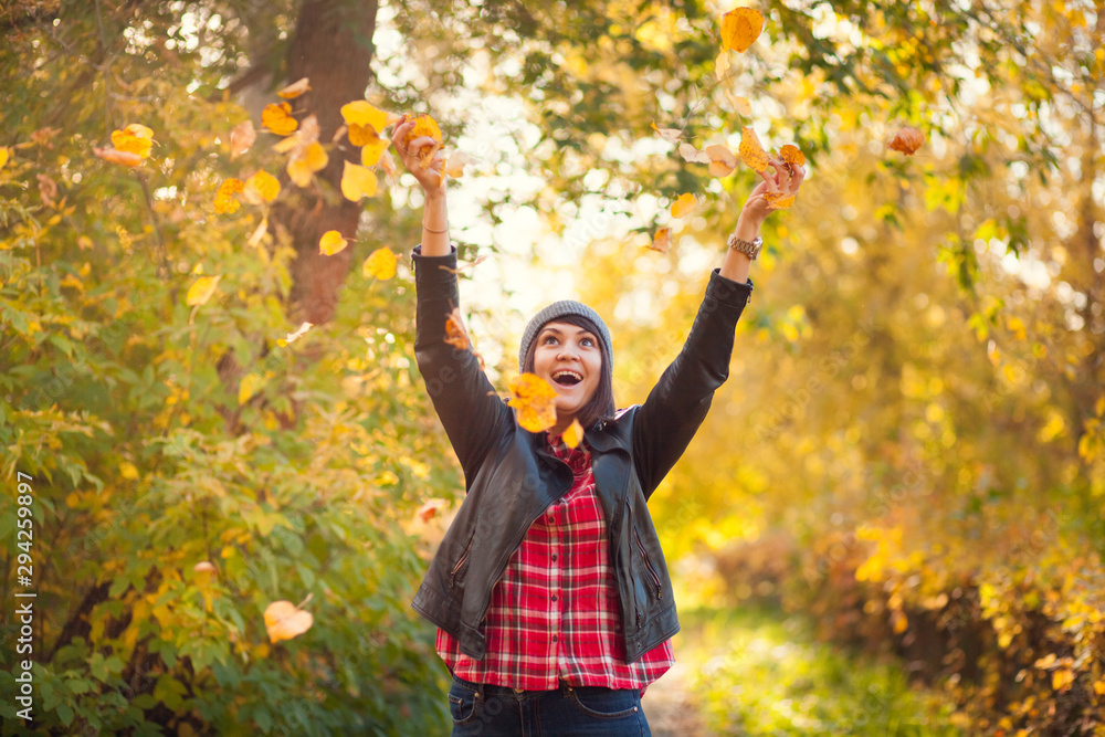 Happy girl throws up yellow leaves in autumn park Happy girl throws up yellow leaves in autumn park