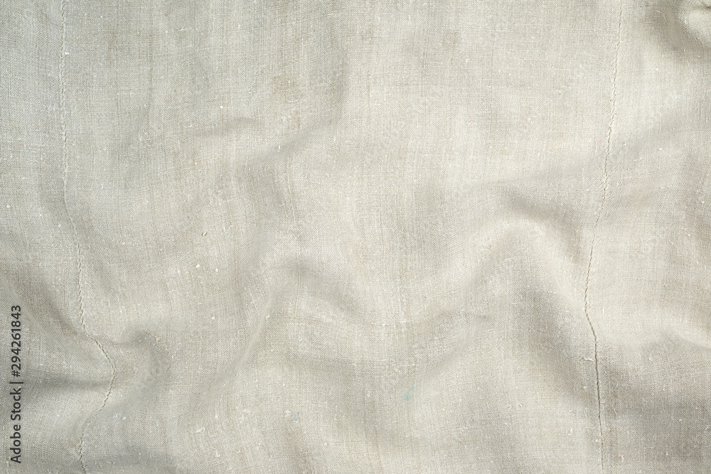 Naklejka premium fragment of a very old linen homespun fabric with waves on the surface