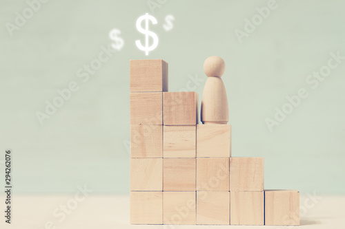 Wooden figure climb to upper stage above which are drawn dollar signs.