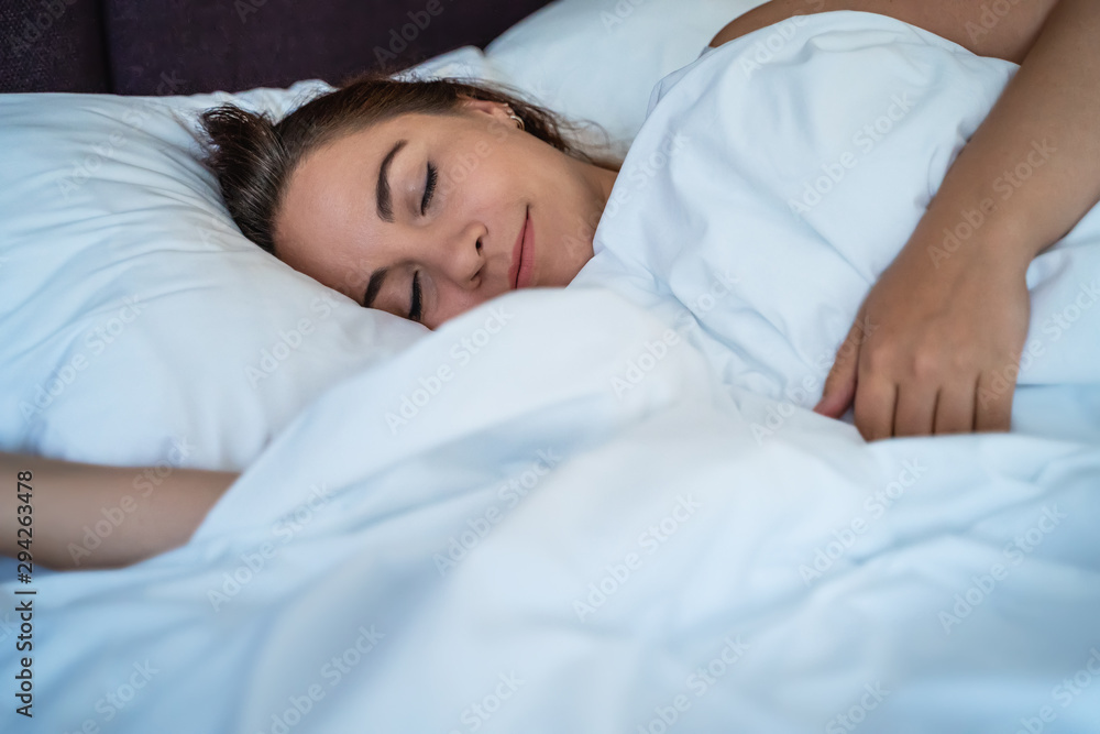 Young beautiful girl or woman sleeps alone in big bed, close up Young beautiful girl or woman sleeps alone in big bed, close up