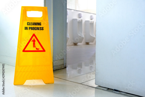 Caution wet floor label in toilet. cleaning toilet in office.
