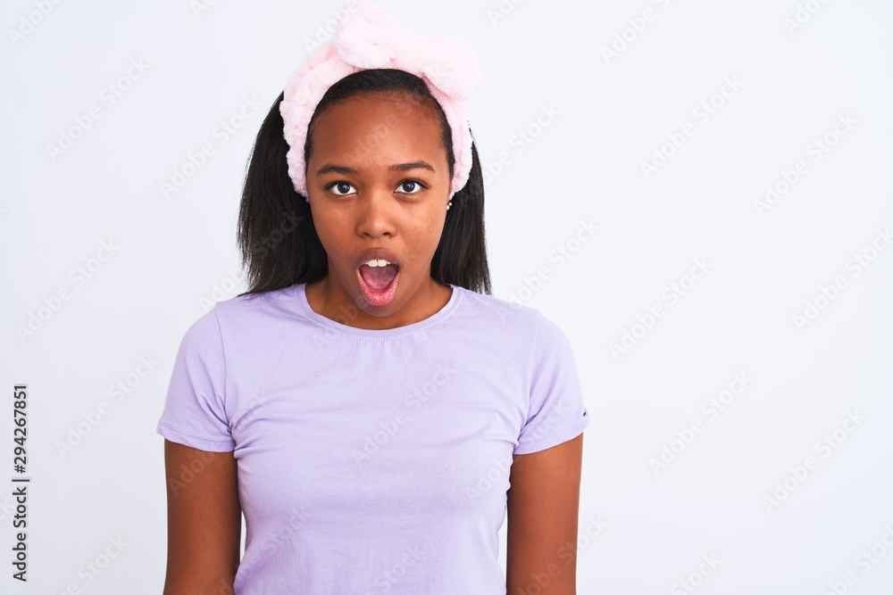 Beautiful young african american woman wearing a beauty diadem over isolated background scared in shock with a surprise face, afraid and excited with fear expression Beautiful young african american woman wearing a beauty diadem over isolated background scared in shock with a surprise face, afraid and excited with fear expression