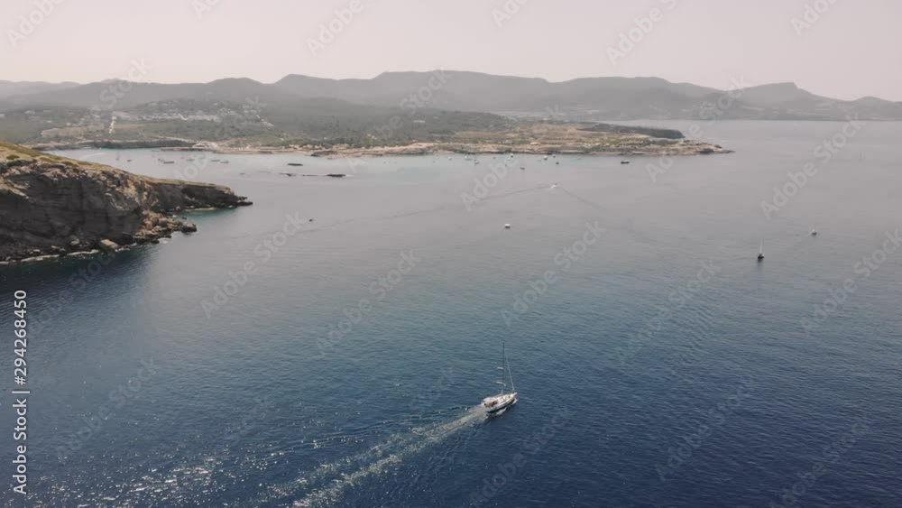Aerial View of yachts near rocky Ibiza island. Drone footage of yachting in the Balearic islands Aerial View of yachts near rocky Ibiza island. Drone footage of yachting in the Balearic islands