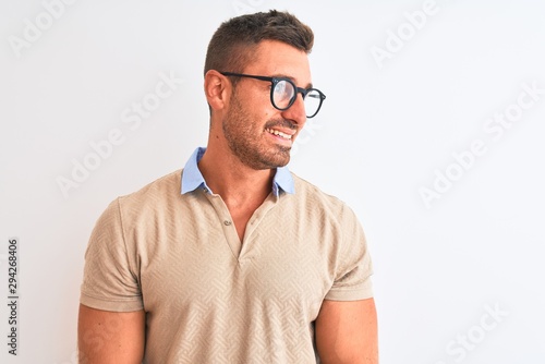 Young handsome man wearing glasses over isolated background looking away to side with smile on face, natural expression. Laughing confident. © Krakenimages.com