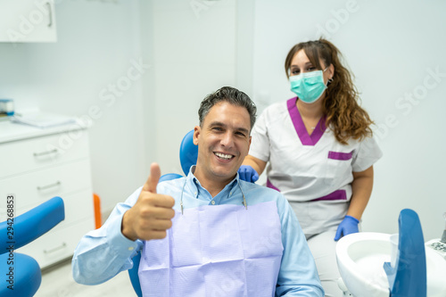 Male Patient at the Dentist Dentist Smiling to the Camera.