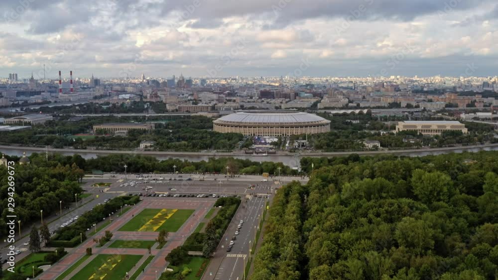 Drone aerial shoot fly over zoom in of stadium Luzhniki and green park with river in Moscow. Sport stadium Luzhniki aerial shot view in summer Drone aerial shoot fly over zoom in of stadium Luzhniki and green park with river in Moscow. Sport stadium Luzhniki aerial shot view in summer