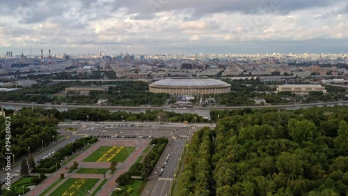 Drone aerial shoot fly over zoom in of stadium Luzhniki and green park with river in Moscow. Sport stadium Luzhniki aerial shot view in summer