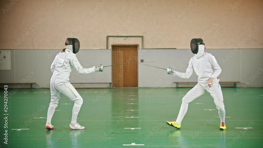 Two young women at fencing training in the gym Two young women at fencing training in the gym