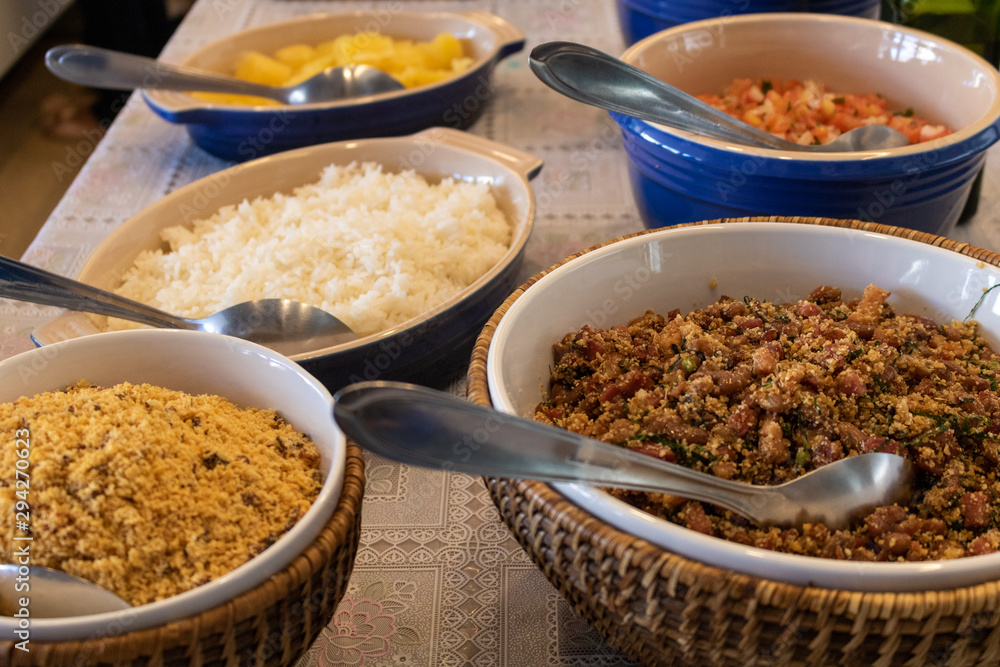 typical brazilian food, rice, beans (feijão tropeiro), farofa, vinaigrette, cooked cassava typical brazilian food, rice, beans (feijão tropeiro), farofa, vinaigrette, cooked cassava