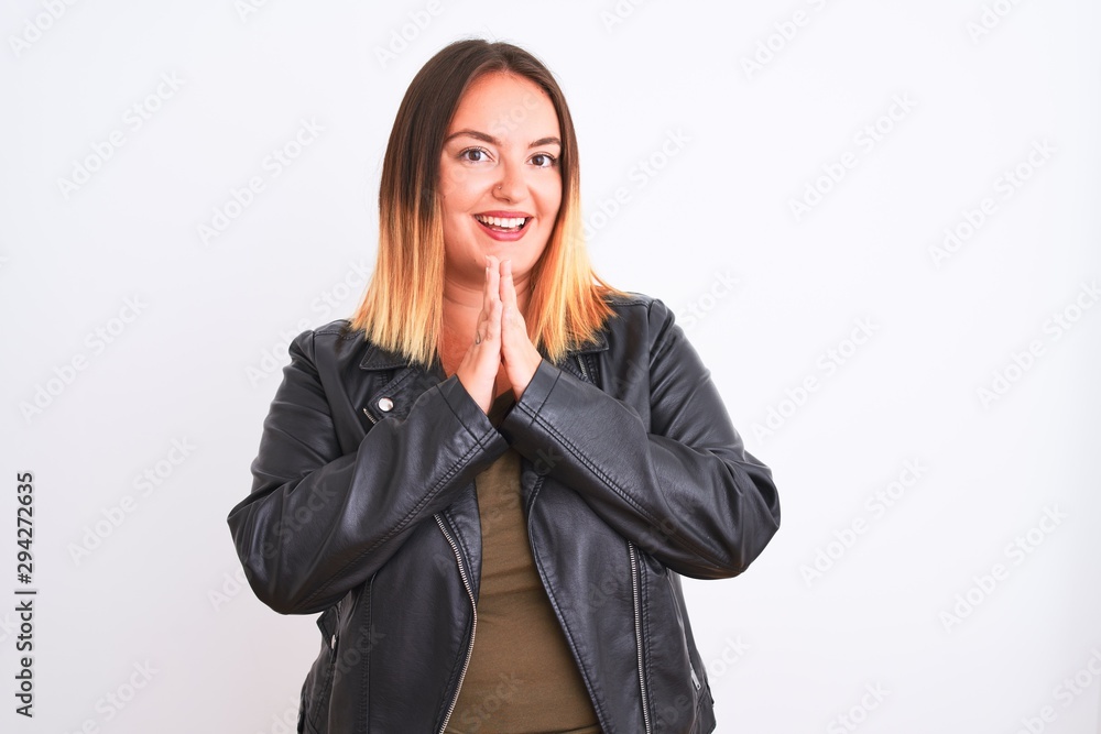 Young beautiful woman wearing t-shirt and jacket standing over isolated white background praying with hands together asking for forgiveness smiling confident. Young beautiful woman wearing t-shirt and jacket standing over isolated white background praying with hands together asking for forgiveness smiling confident.