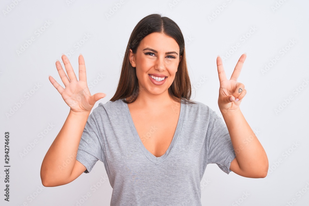 Portrait of beautiful young woman standing over isolated white background showing and pointing up with fingers number seven while smiling confident and happy. Portrait of beautiful young woman standing over isolated white background showing and pointing up with fingers number seven while smiling confident and happy.