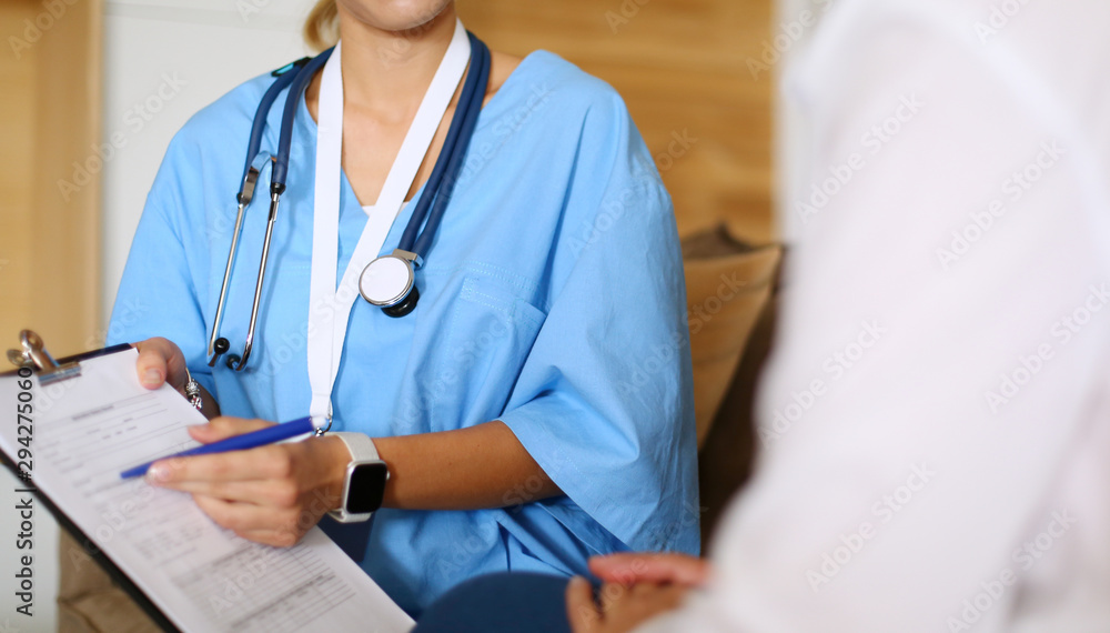 Woman doctor explaining diagnosis to her female patient Woman doctor explaining diagnosis to her female patient
