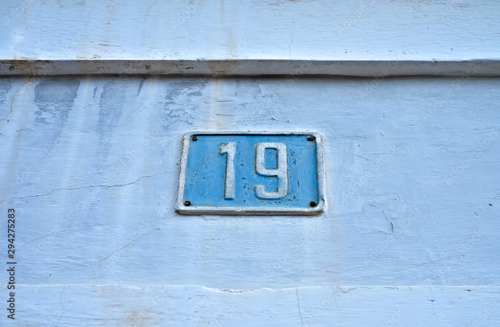 Number 19, nineteen, blue plate on light weathered background. Number 19, nineteen, blue plate on light weathered background.