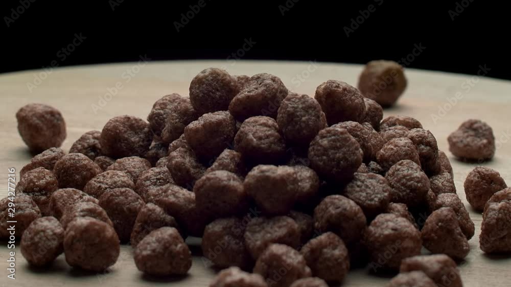 Chocolate cereal flakes rotates on a wooden board Chocolate cereal flakes rotates on a wooden board