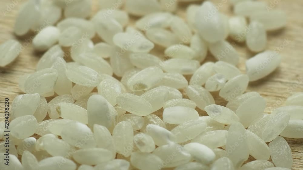 White short grain rice rotates on a wooden board White short grain rice rotates on a wooden board