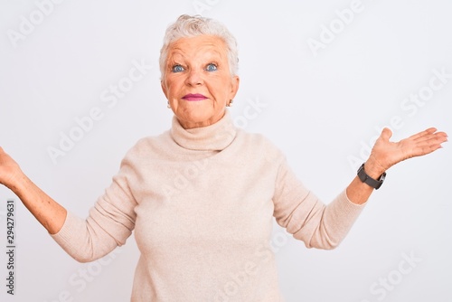 Senior grey-haired woman wearing turtleneck sweater standing over isolated white background smiling showing both hands open palms, presenting and advertising comparison and balance