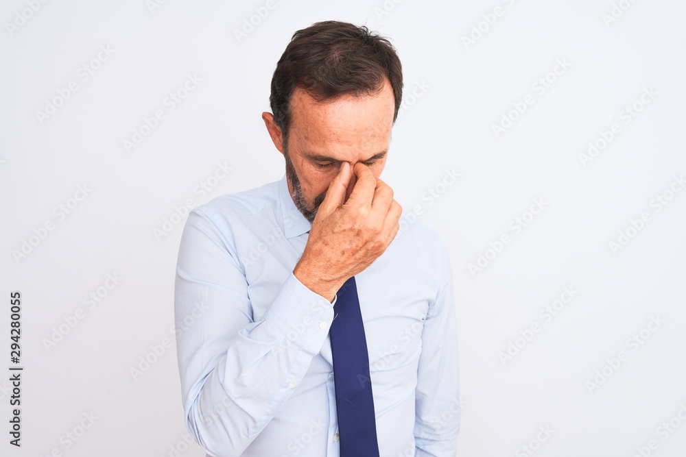 Middle age businessman wearing elegant tie standing over isolated white background tired rubbing nose and eyes feeling fatigue and headache. Stress and frustration concept. Middle age businessman wearing elegant tie standing over isolated white background tired rubbing nose and eyes feeling fatigue and headache. Stress and frustration concept.