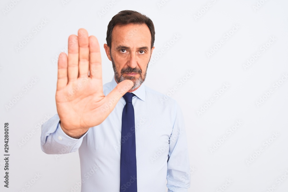 Middle age businessman wearing elegant tie standing over isolated white background doing stop sing with palm of the hand. Warning expression with negative and serious gesture on the face. Middle age businessman wearing elegant tie standing over isolated white background doing stop sing with palm of the hand. Warning expression with negative and serious gesture on the face.
