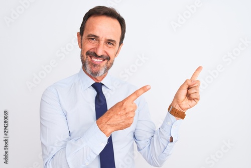 Middle age businessman wearing elegant tie standing over isolated white background smiling and looking at the camera pointing with two hands and fingers to the side.