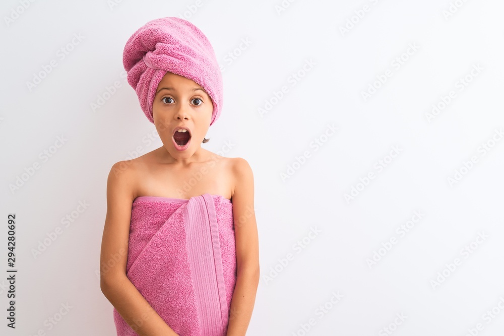 Beautiful child girl wearing shower towel after bath standing over isolated white background afraid and shocked with surprise expression, fear and excited face. Beautiful child girl wearing shower towel after bath standing over isolated white background afraid and shocked with surprise expression, fear and excited face.
