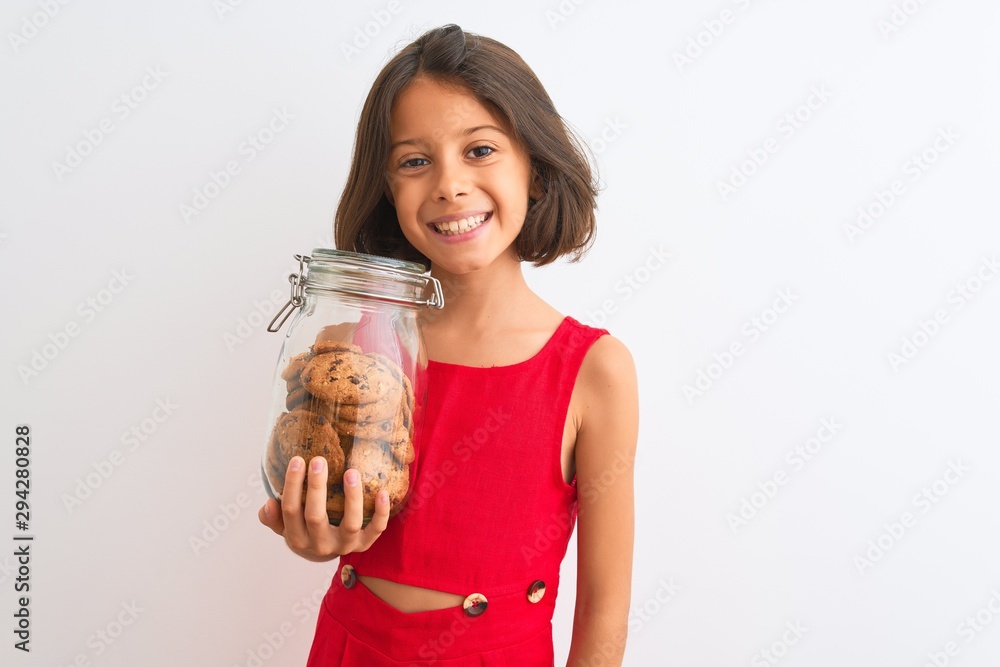 Beautiful child girl holding jar of cookies standing over isolated white background with a happy face standing and smiling with a confident smile showing teeth Beautiful child girl holding jar of cookies standing over isolated white background with a happy face standing and smiling with a confident smile showing teeth