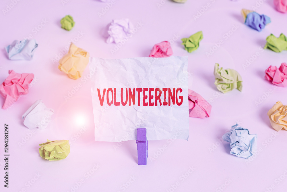 Handwriting text Volunteering. Conceptual photo Provide services for no financial gain Willingly Oblige Colored crumpled papers empty reminder white floor background clothespin