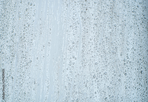 Shiny, metallic background, covered with water drops. Texture of water on a metal surface.