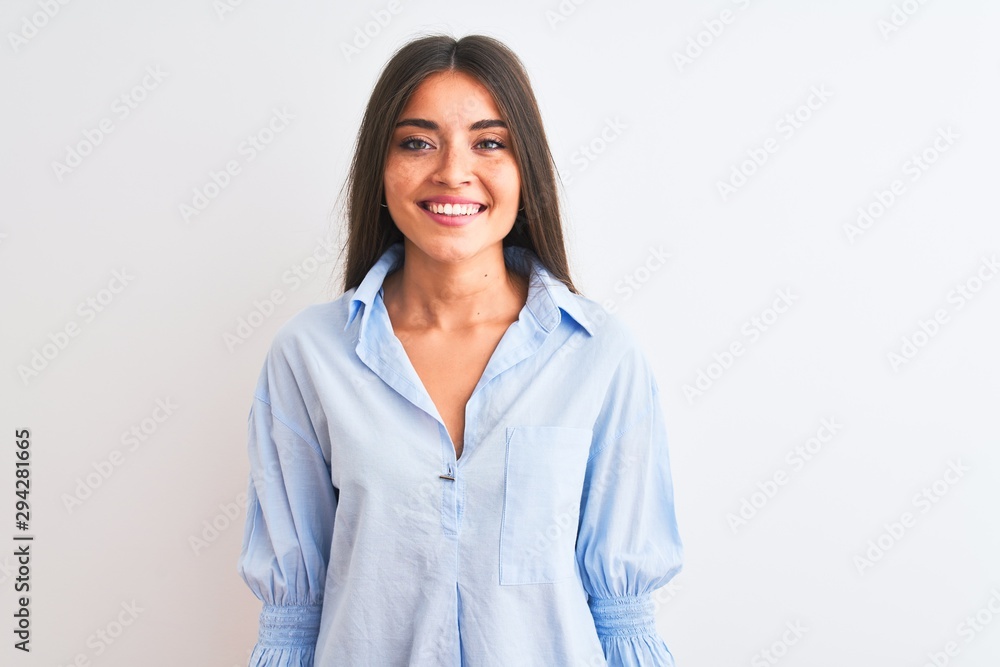 Young beautiful woman wearing blue elegant shirt standing over isolated white background with a happy and cool smile on face. Lucky person. Young beautiful woman wearing blue elegant shirt standing over isolated white background with a happy and cool smile on face. Lucky person.