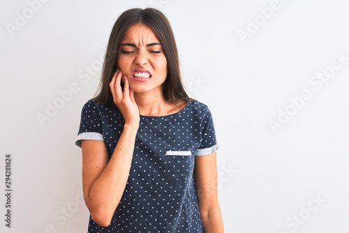 Young beautiful woman wearing blue casual t-shirt standing over isolated white background touching mouth with hand with painful expression because of toothache or dental illness on teeth