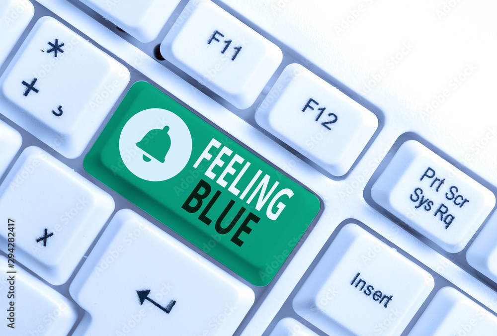 Conceptual hand writing showing Feeling Blue. Concept meaning Feeling of desperation because of sadness or missing someone White pc keyboard with note paper above the white background Conceptual hand writing showing Feeling Blue. Concept meaning Feeling of desperation because of sadness or missing someone White pc keyboard with note paper above the white background