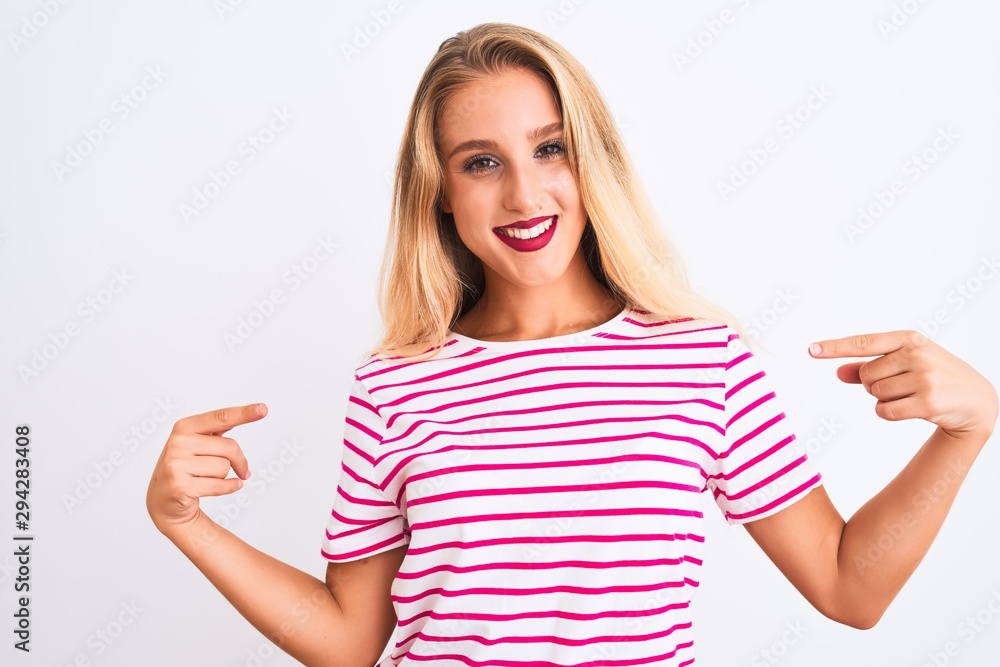 Young beautiful woman wearing pink striped t-shirt standing over isolated white background looking confident with smile on face, pointing oneself with fingers proud and happy. Young beautiful woman wearing pink striped t-shirt standing over isolated white background looking confident with smile on face, pointing oneself with fingers proud and happy.