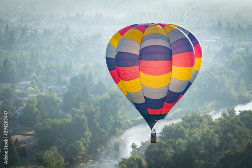 Colorful hot air balloon over the Rogue River in Grants Pass Oregon on a beautiful summer morning
