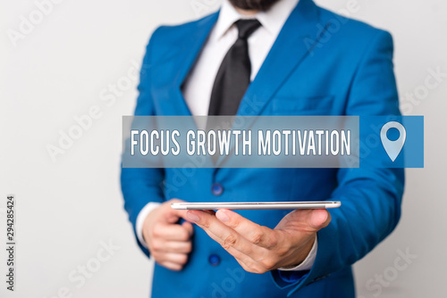 Writing note showing Focus Growth Motivation. Business concept for doing something with accuracy increase productivity Businessman in blue suite with a tie holds lap top in hands photo