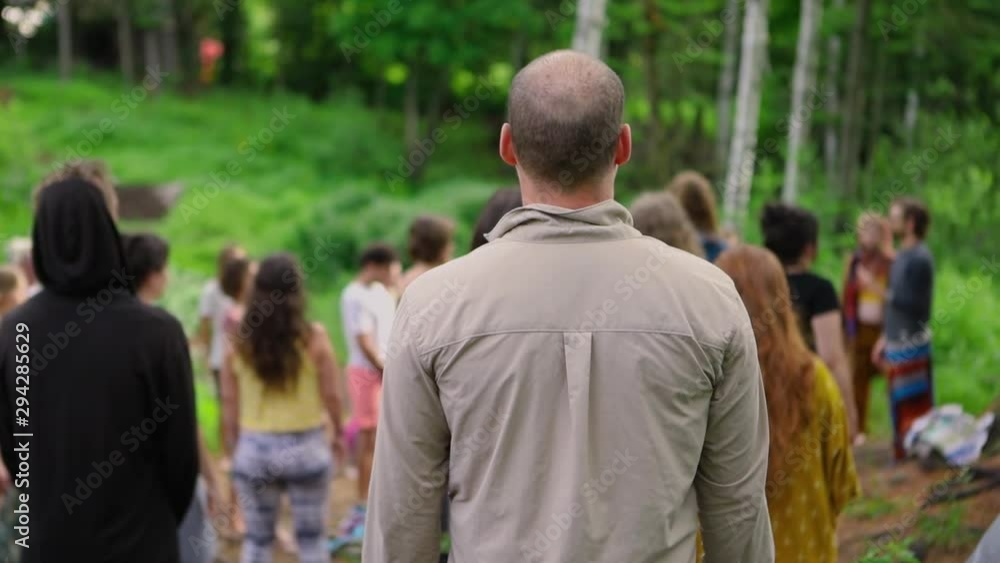 Diverse people enjoy spiritual gathering A middle aged caucasian guy with short balding hair is seen from the rear, standing amongst a large group of people enjoying spirituality in nature. Diverse people enjoy spiritual gathering A middle aged caucasian guy with short balding hair is seen from the rear, standing amongst a large group of people enjoying spirituality in nature.