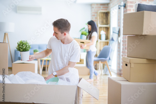 Young beautiful couple open cardboard boxes to order new home